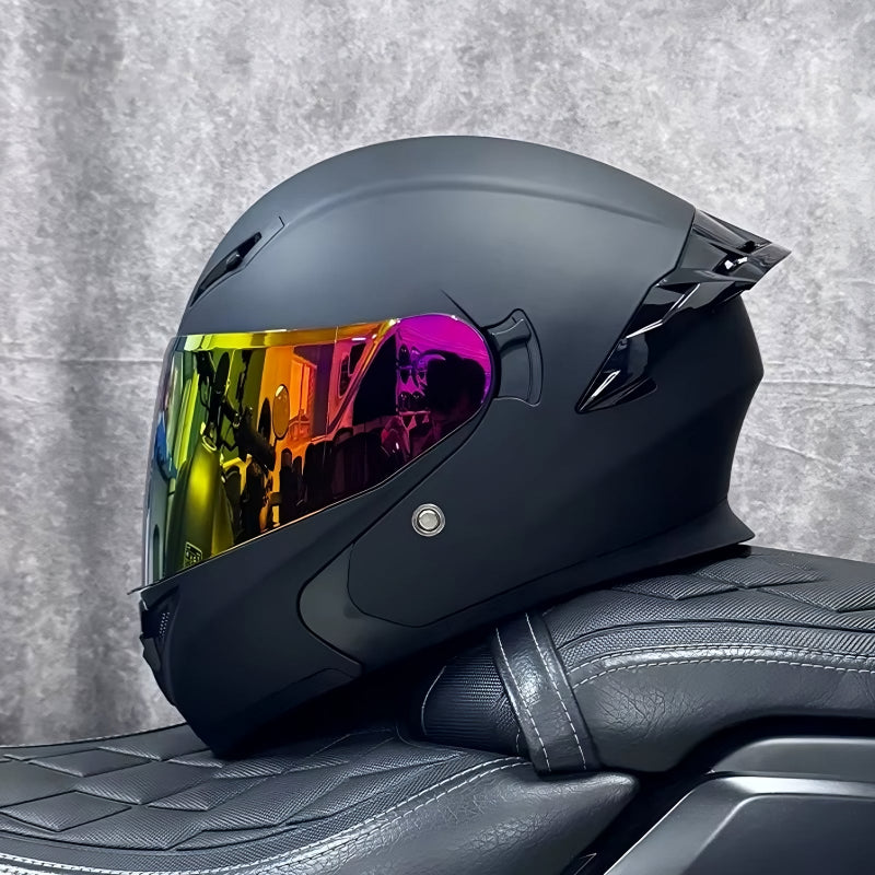Black motorcycle helmet with colorful visor on a textured gray background
