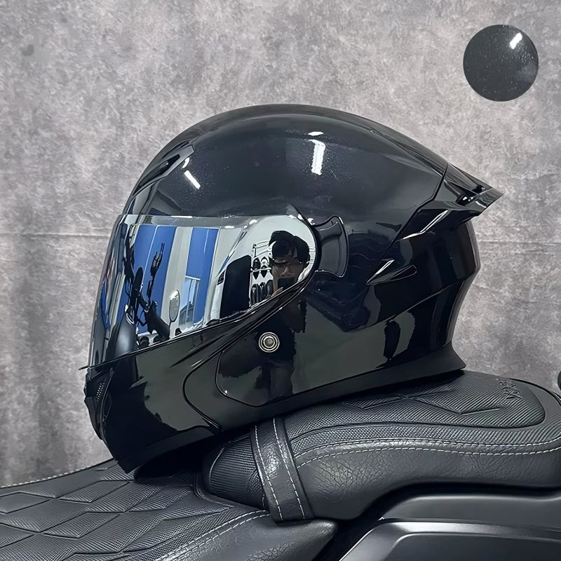 Black motorcycle helmet on a textured gray surface