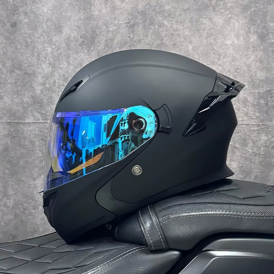 Black motorcycle helmet with a blue visor on a gray textured background