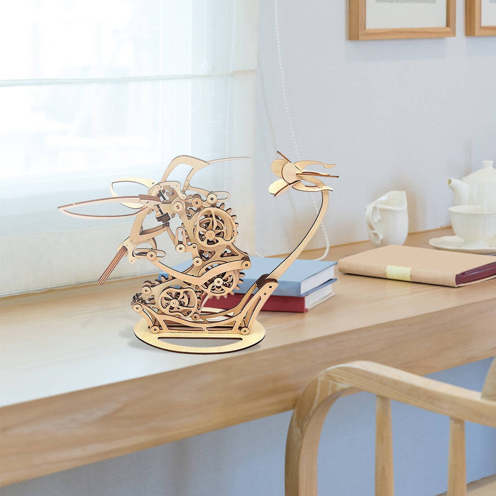 Wooden sailboat model on a desk with books and a teapot Puzzloria | Kinetic Hummingbird Sculpture - 3D Wooden Mechanical Puzzle Kit