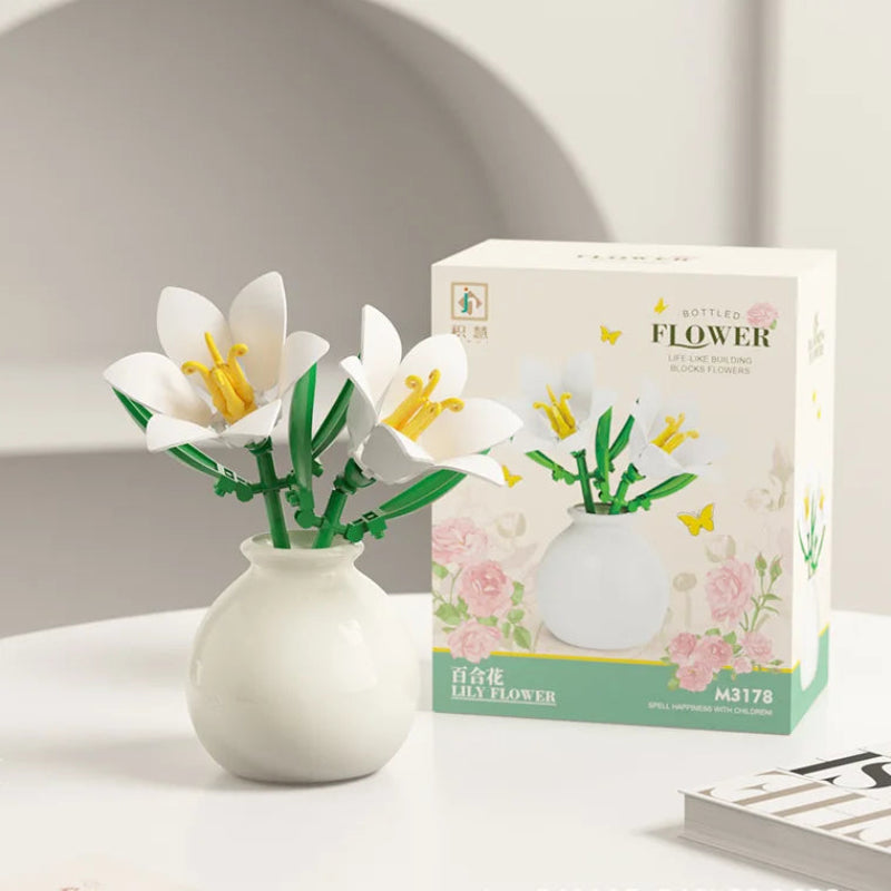 White vase with decorative flowers next to its packaging on a light surface.