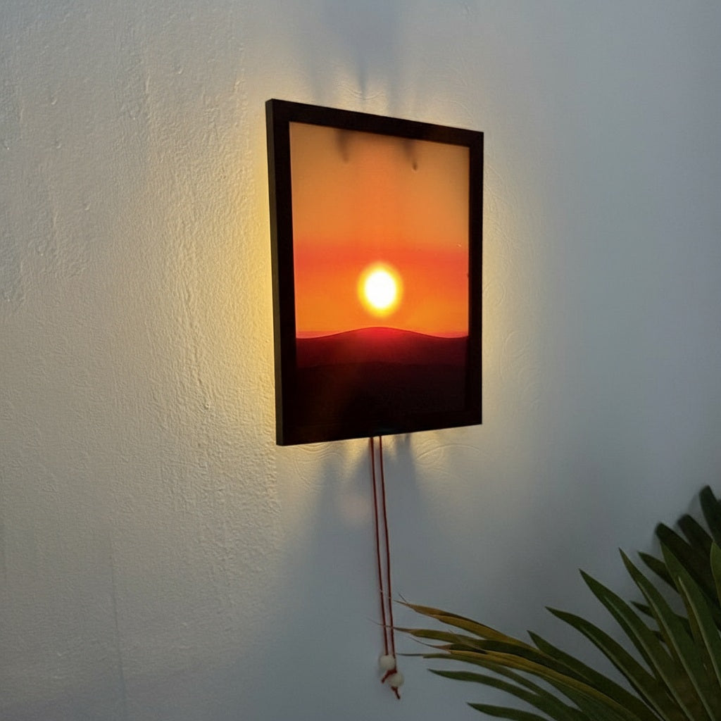 Wall-mounted light fixture with a sunset design on a white wall.