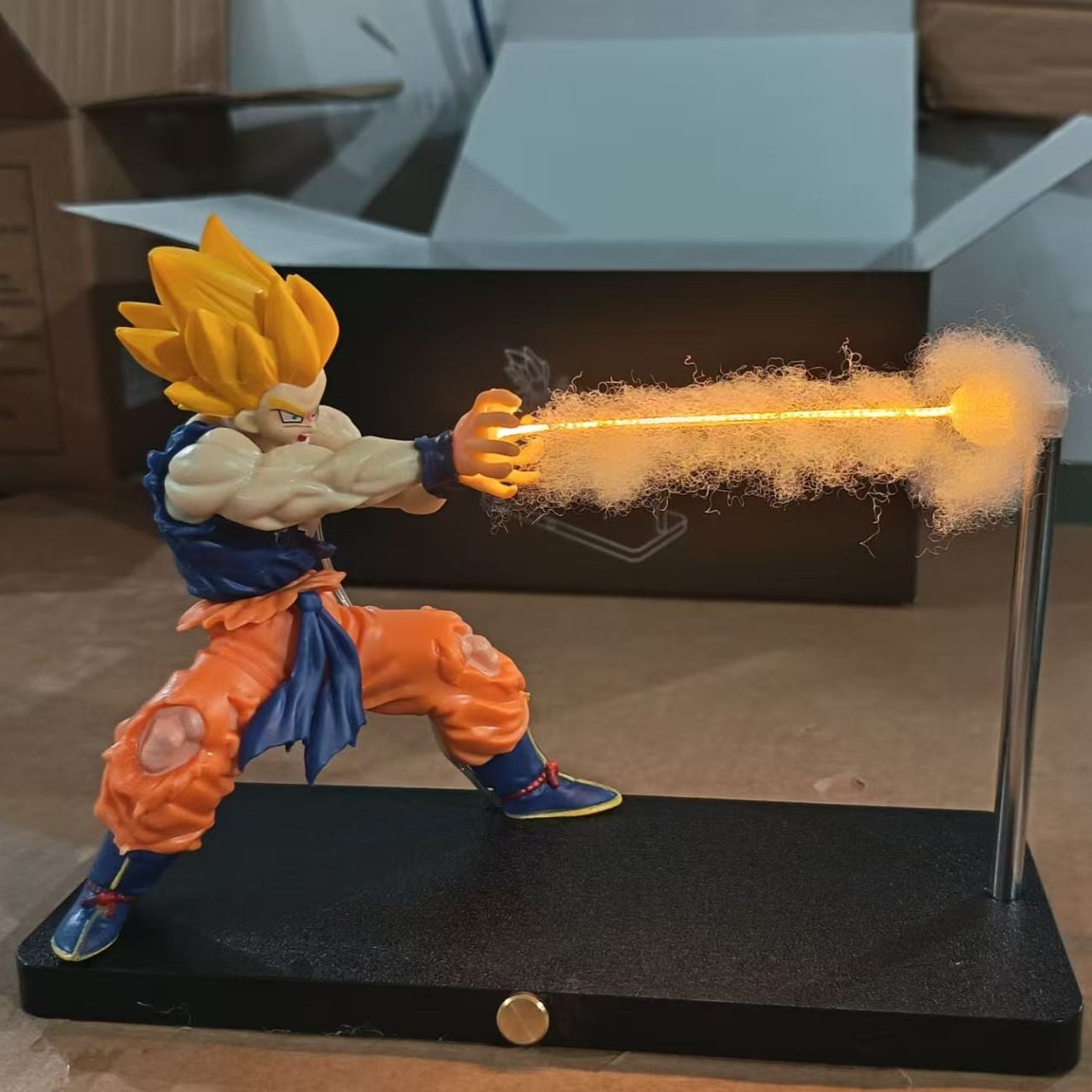 Super Saiyan Goku figure with energy blast on a stand