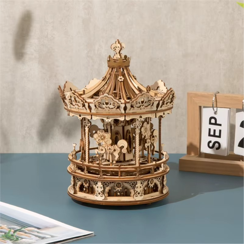 Wooden carousel model on a table with a neutral background