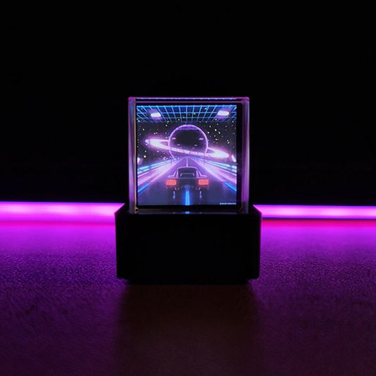 Hologram cube display showing a retro synthwave scene inside its crystal prism on a desk