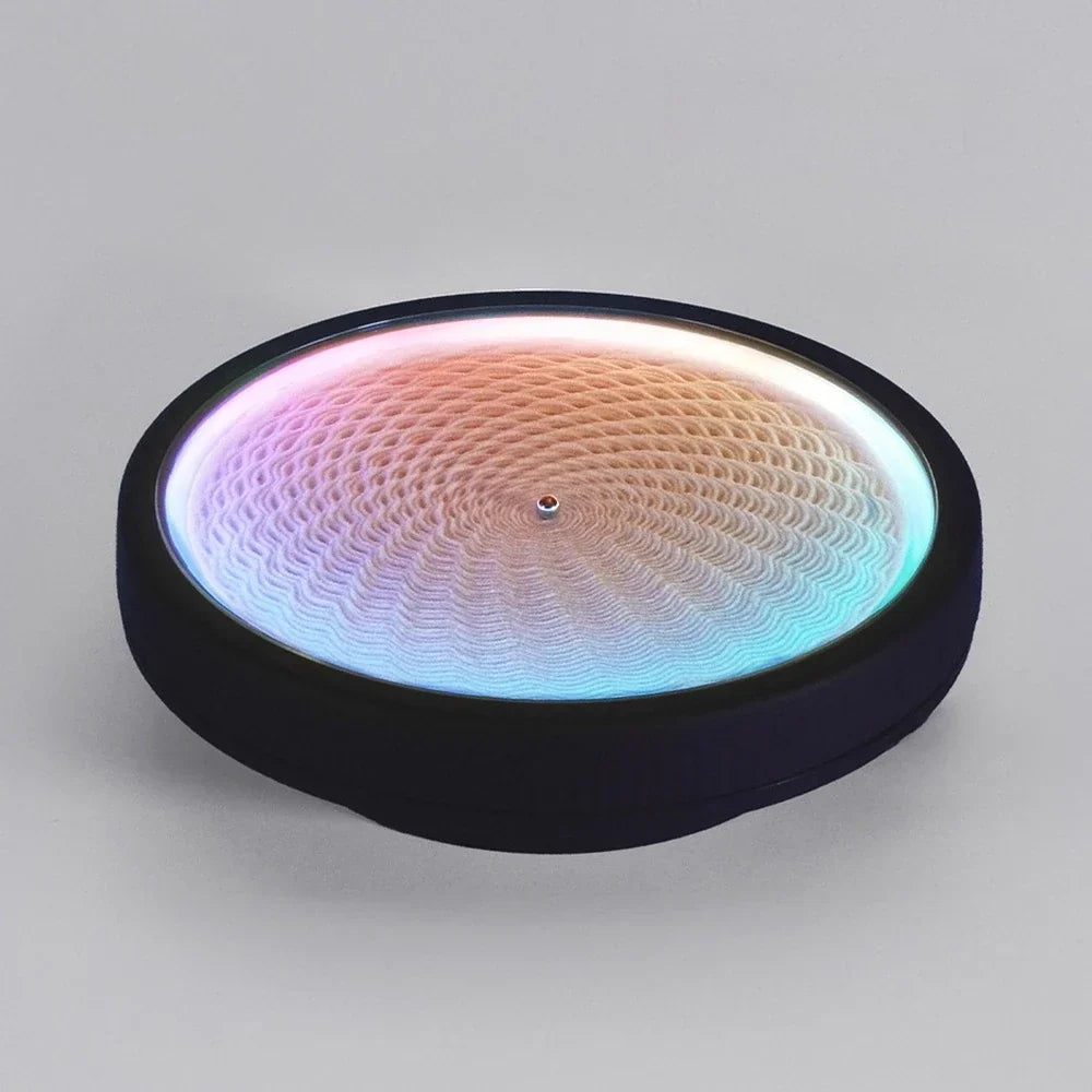 kinetic sand art table with color-changing RGB LED light drawing geometric patterns in white sand