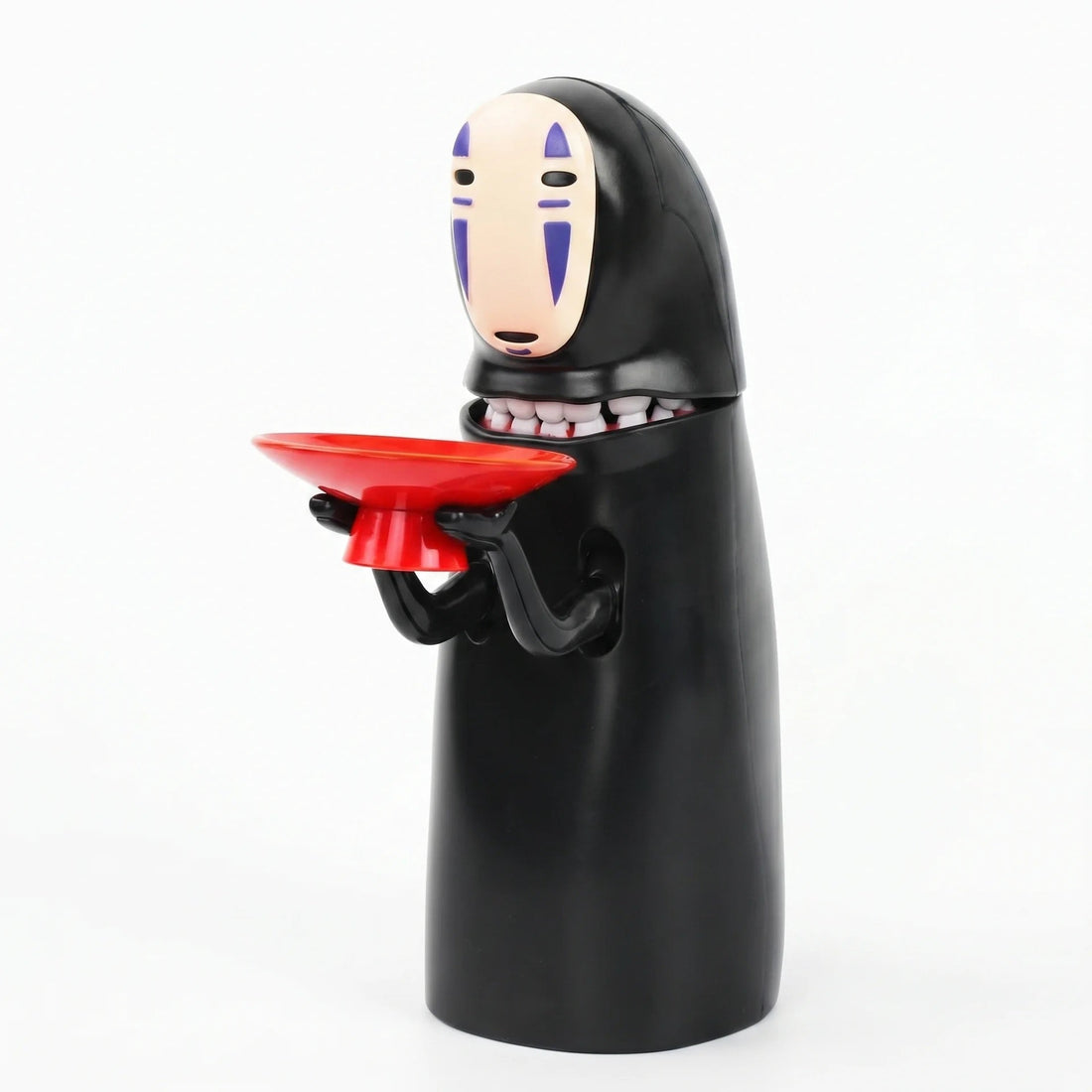 No face coin bank with a red coin tray in its hands, a Kaonashi inspired automatic money box from Puzzloria