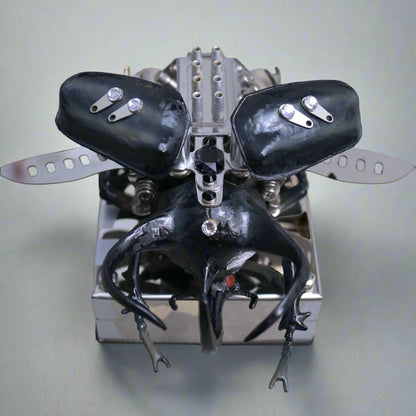 Metallic insect-like creature with black wings and legs on a reflective surface
Puzzloria mechanical model kit DIY assembly engineering educational toy