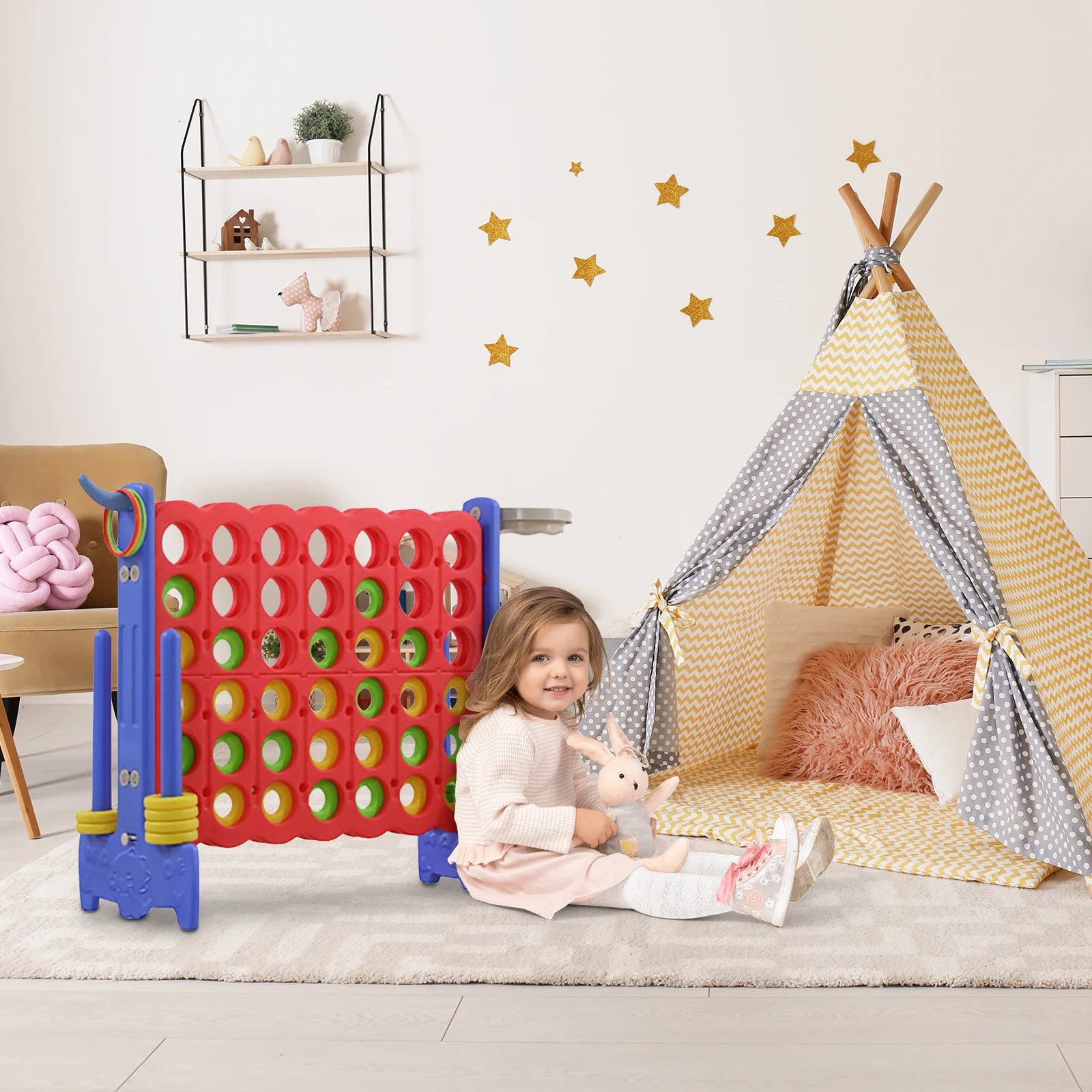 Child playing with a colorful game set in a room with a teepee and star decorations.