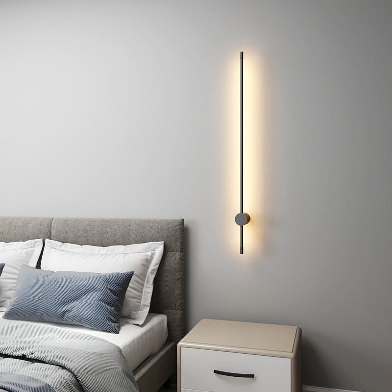 Modern wall sconce in a bedroom setting with a bed and nightstand.