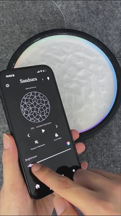 kinetic sand art table in motion drawing zen sand patterns with color-changing LED light, mesmerizing app-controlled desk decor and gift