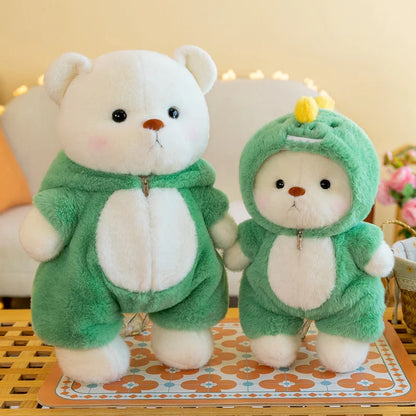 Two plush toys, one white and one green, wearing matching outfits on a decorative surface.