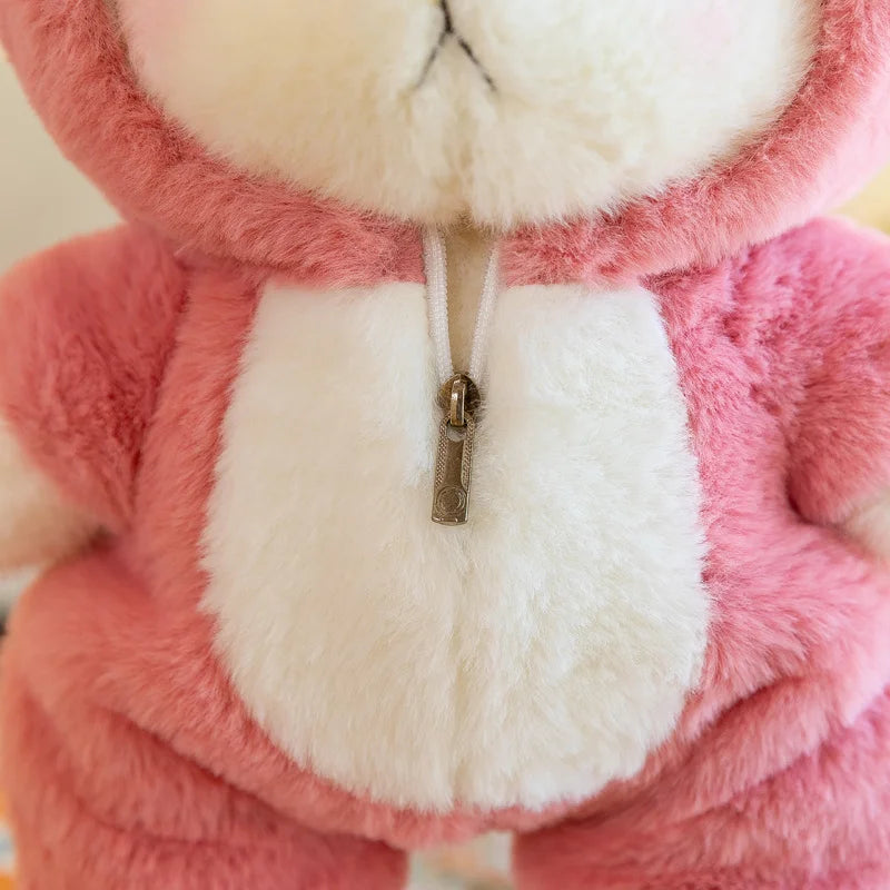 Close-up of a pink plush toy with a white zipper on a beige background