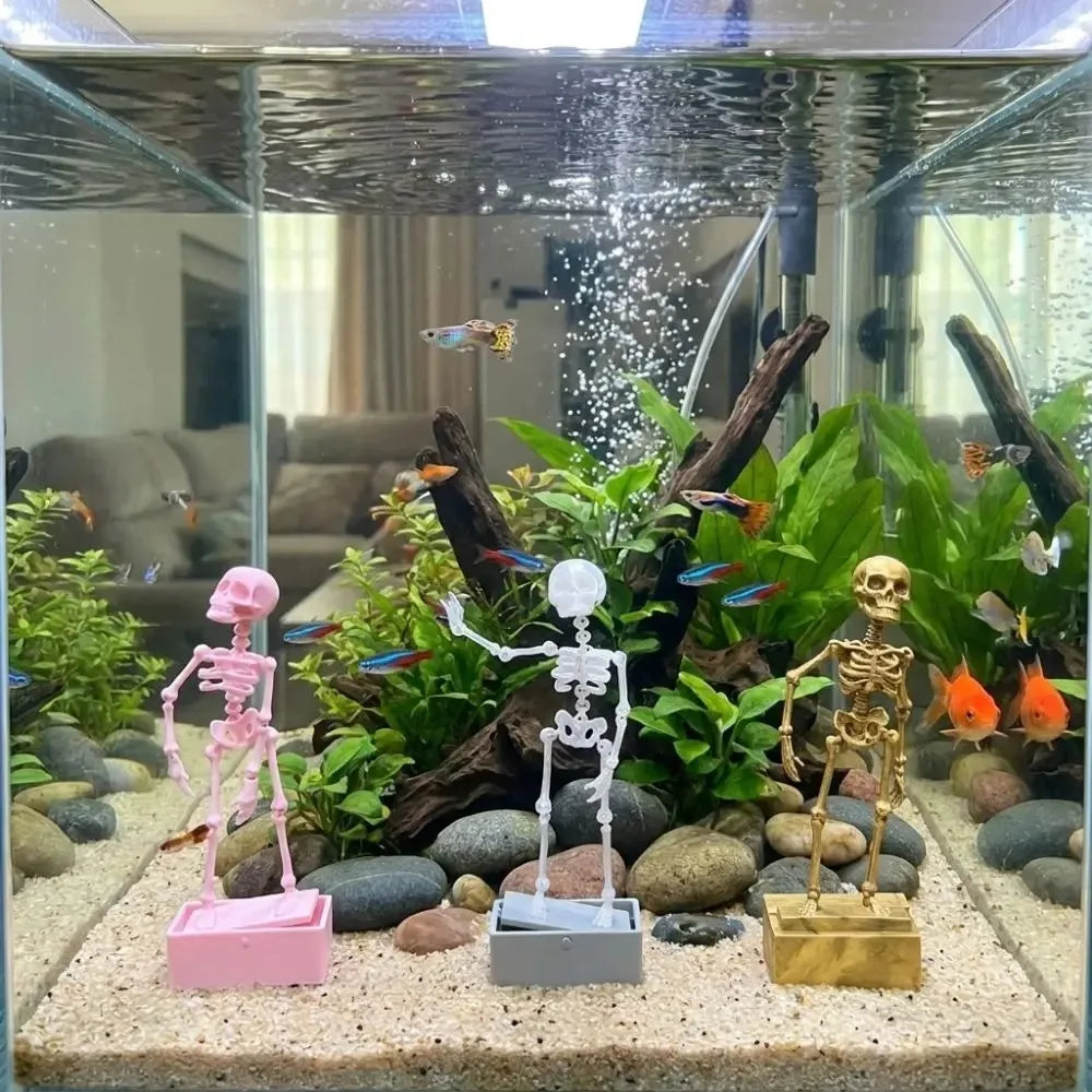 halloween aquarium decor skeleton ornaments displayed in a bright planted goldfish tank as a gift for fish keepers