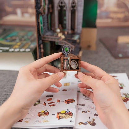 Hands assembling a small wooden model with an instruction manual in the background, featuring the text 'Easy Assembly'.