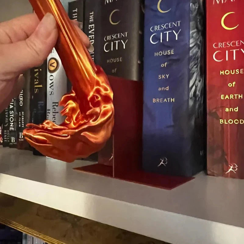 sculpted flame piece held in hand showing the glossy gradient finish and the fire splash base that sits between books