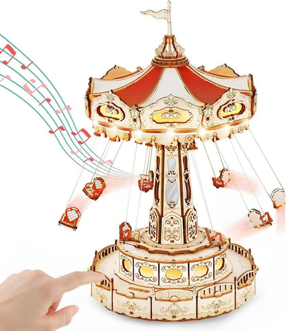 enchanted carousel music box with red and white flying chairs suspended from the rotating canopy roof