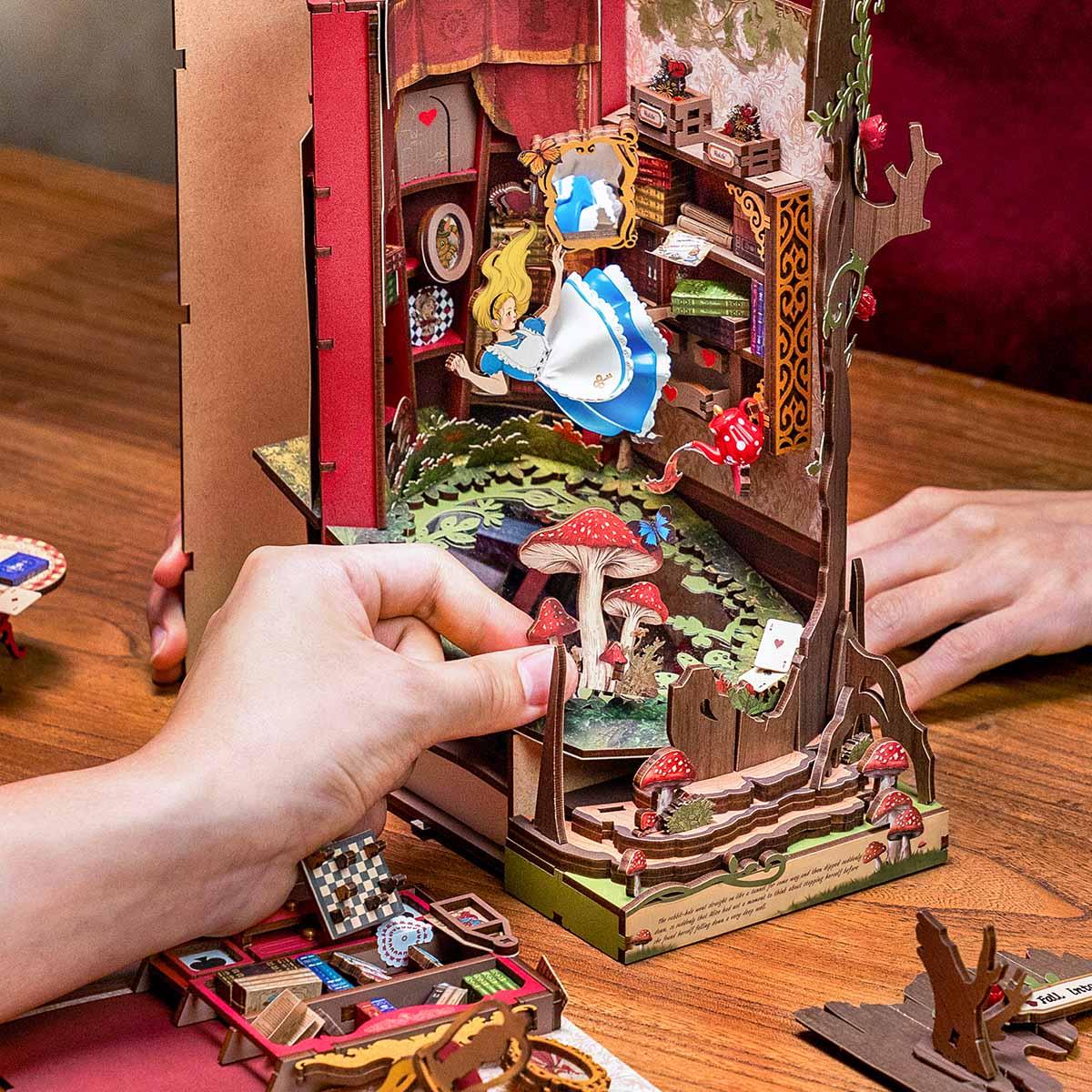hands assembling a laser cut wooden book nook kit on a desk, relaxing diy craft project for adults and teens