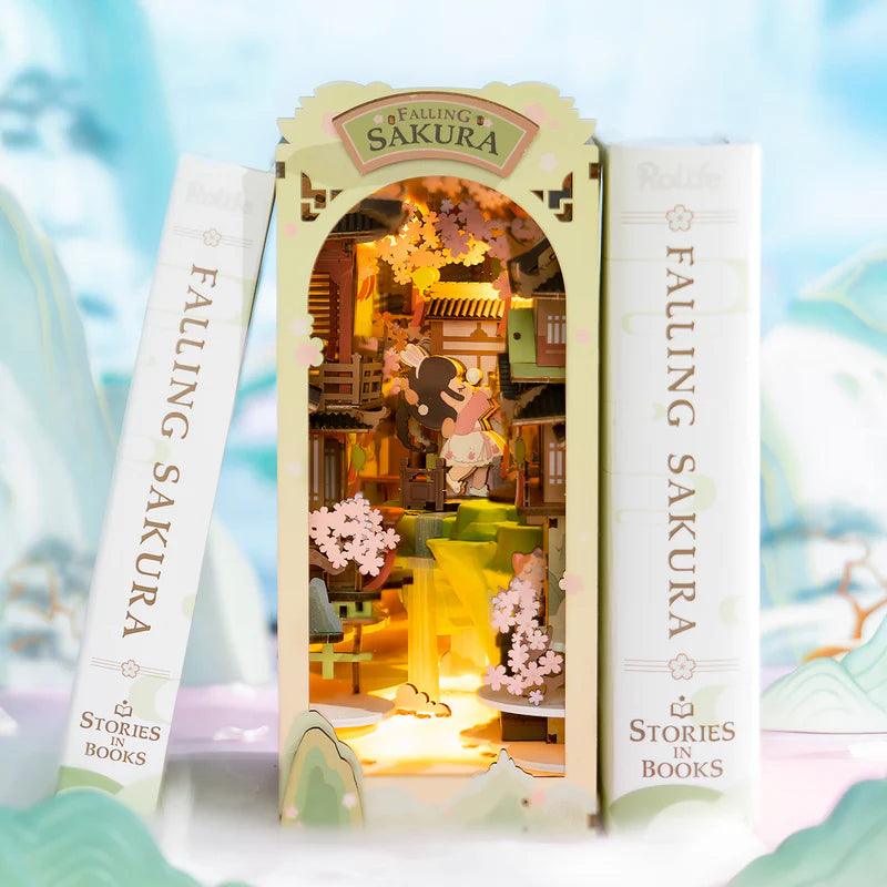 book nook cherry blossom diorama slotted between novels on a shelf as japanese style reading corner decor