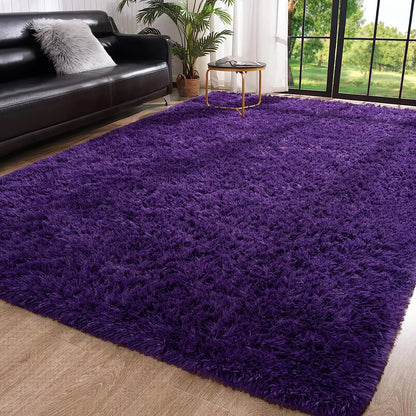 Purple rug in a living room with a black sofa and a small table.