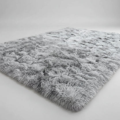 Child playing with a small dog on a fluffy gray rug in a room with colorful wall art.