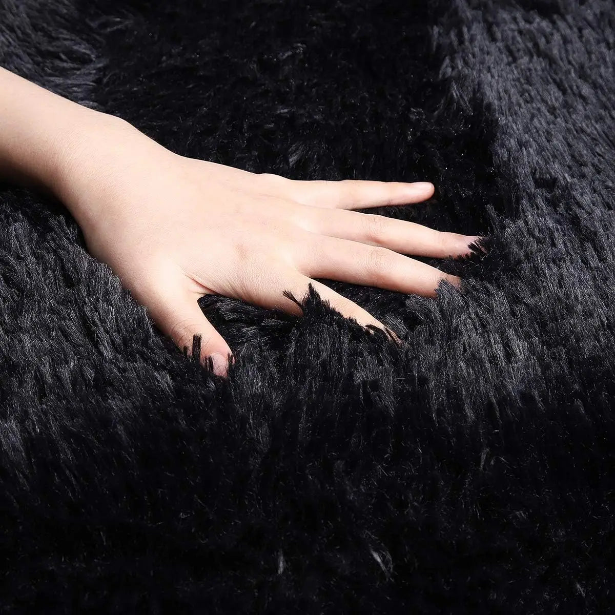 Hand with black nail polish on a black Puzzloria Fluffy Shag Area Rug Cozy Home Decor Plush Carpet