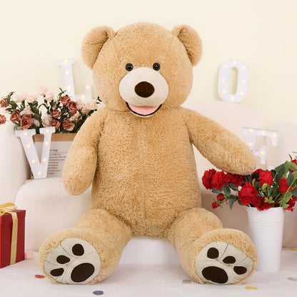 Large teddy bear holding flowers in a decorative setting with lights and flowers.