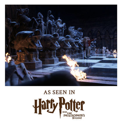 Scene from 'Harry Potter' with stone statues and flames, text indicating movie reference.