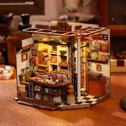 miniature chocolate shop interior with tiny confectionery trays, jars and a vintage cash register model