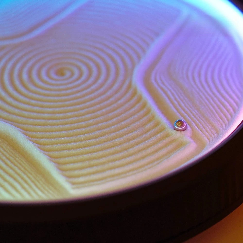 fine white sand sculpted into spiral and wave grooves by a kinetic sand art table, soothing decompression desk decor and gift