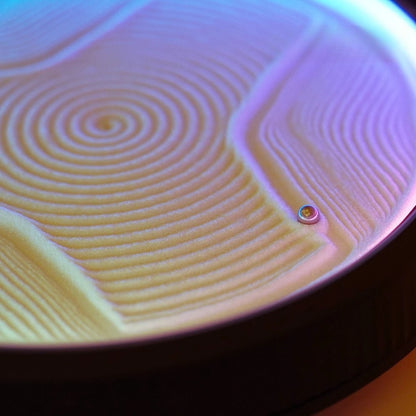 fine white sand sculpted into spiral and wave grooves by a kinetic sand art table, soothing decompression desk decor and gift