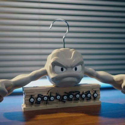 Geodude clothes hanger on a desk display stand with Pokemon figures, collectible novelty coat hanger for fan room decor