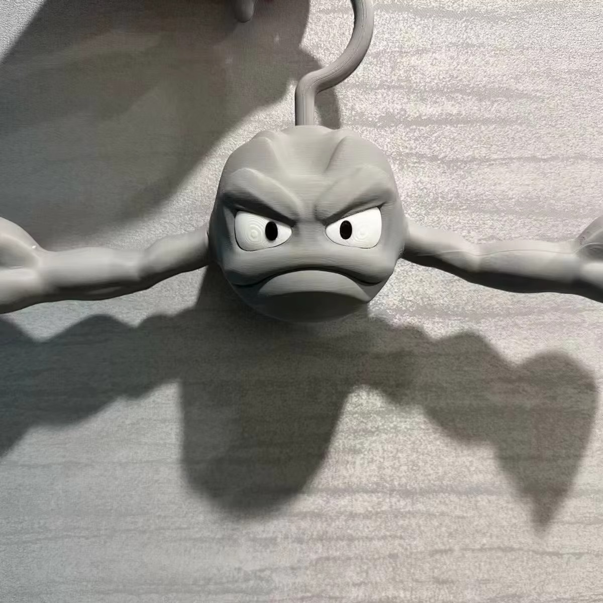 Geodude rock monster hanger angry face close-up with deep eye sockets, anime Pokemon coat hanger detail for fan collectors