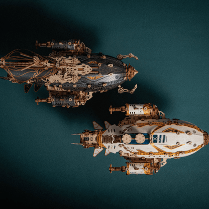 two steampunk airship wooden puzzles seen from above showing both hull colourways side by side, White, Blue