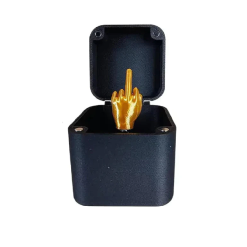 Black jewelry box with a gold middle finger ring inside on a white background