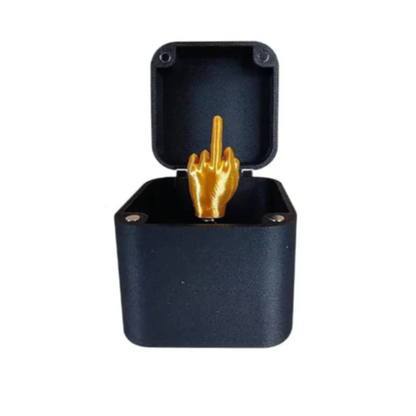 Black jewelry box with a gold middle finger ring inside on a white background