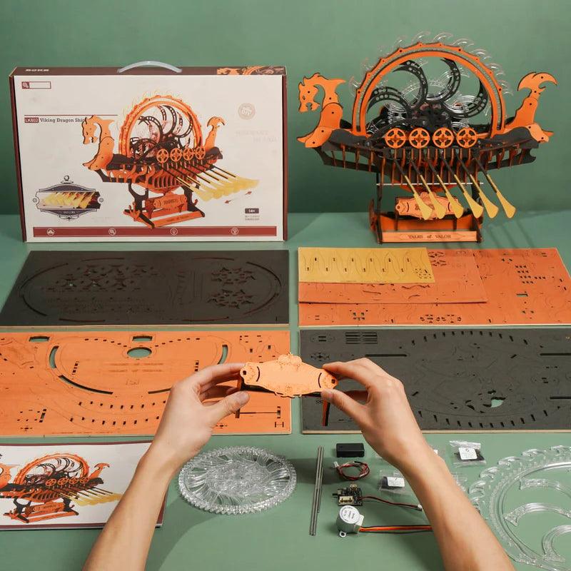 laser cut plywood sheets gift box and hands building the norse drakkar model kit with no glue needed